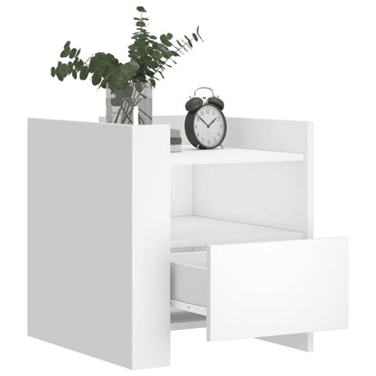 The bedside table with the drawer pulled out and decorative items on the top shelf