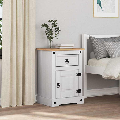 White bedside table in a room next to a bed with curtains