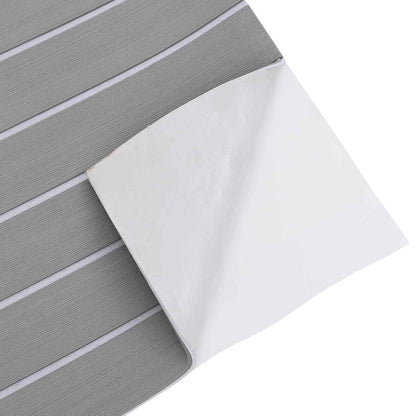 Close-up of the light grey and white striped boat mat with the backing peel partially removed