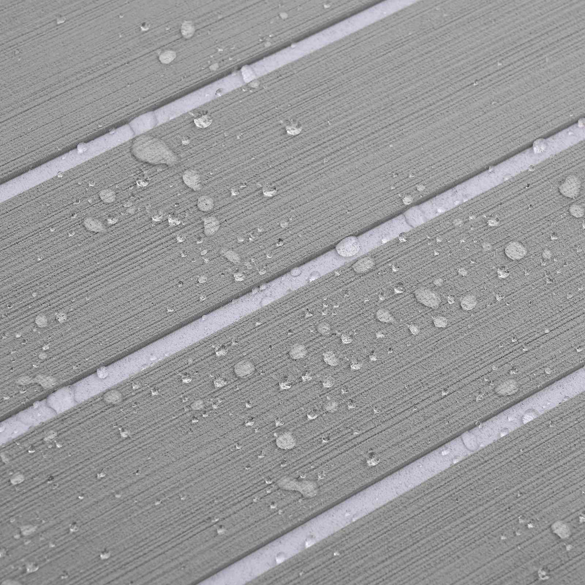 Water droplets on the surface of the light grey and white striped boat mat, showing its water resistance