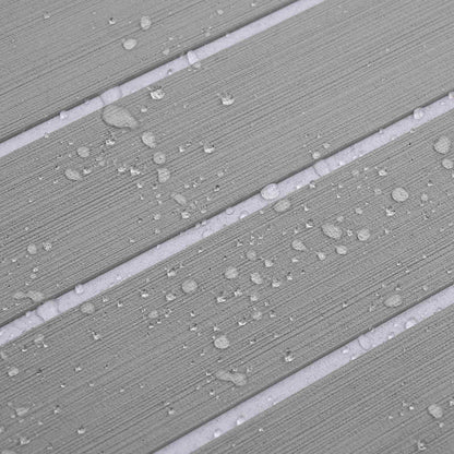 Water droplets on the surface of the light grey and white striped boat mat, showing its water resistance