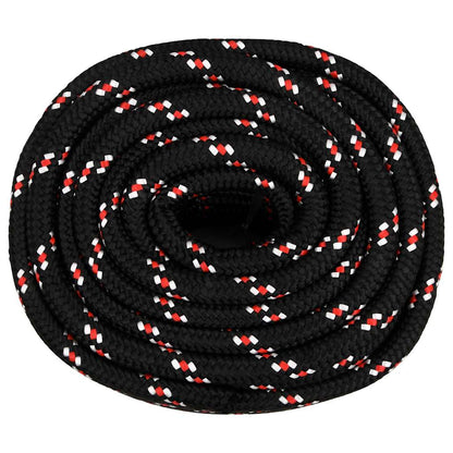 Top down view of a coiled black boat rope with red and white flecks