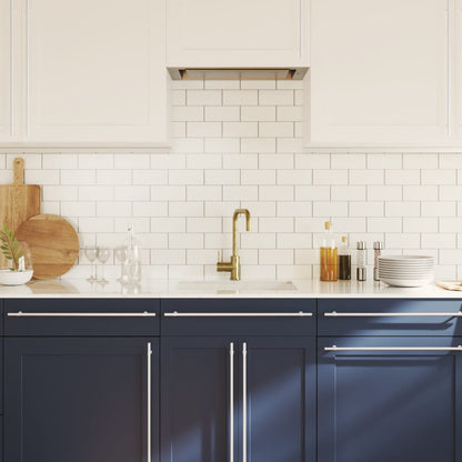 The cabinet handles installed on blue kitchen cupboards in a bright room
