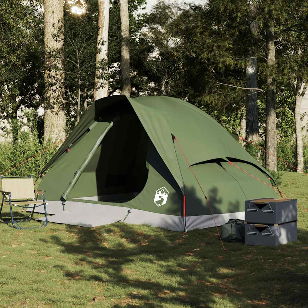 olive green four person camping tent pitched on grass with camping chairs and storage boxes