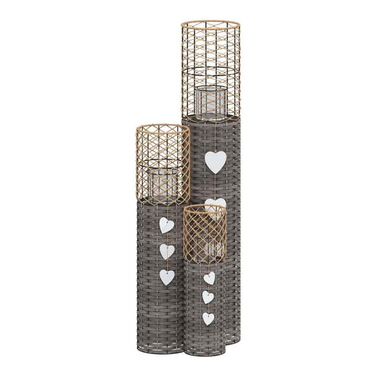 The candle holders arranged in a group with white heart decorations hanging on the sides