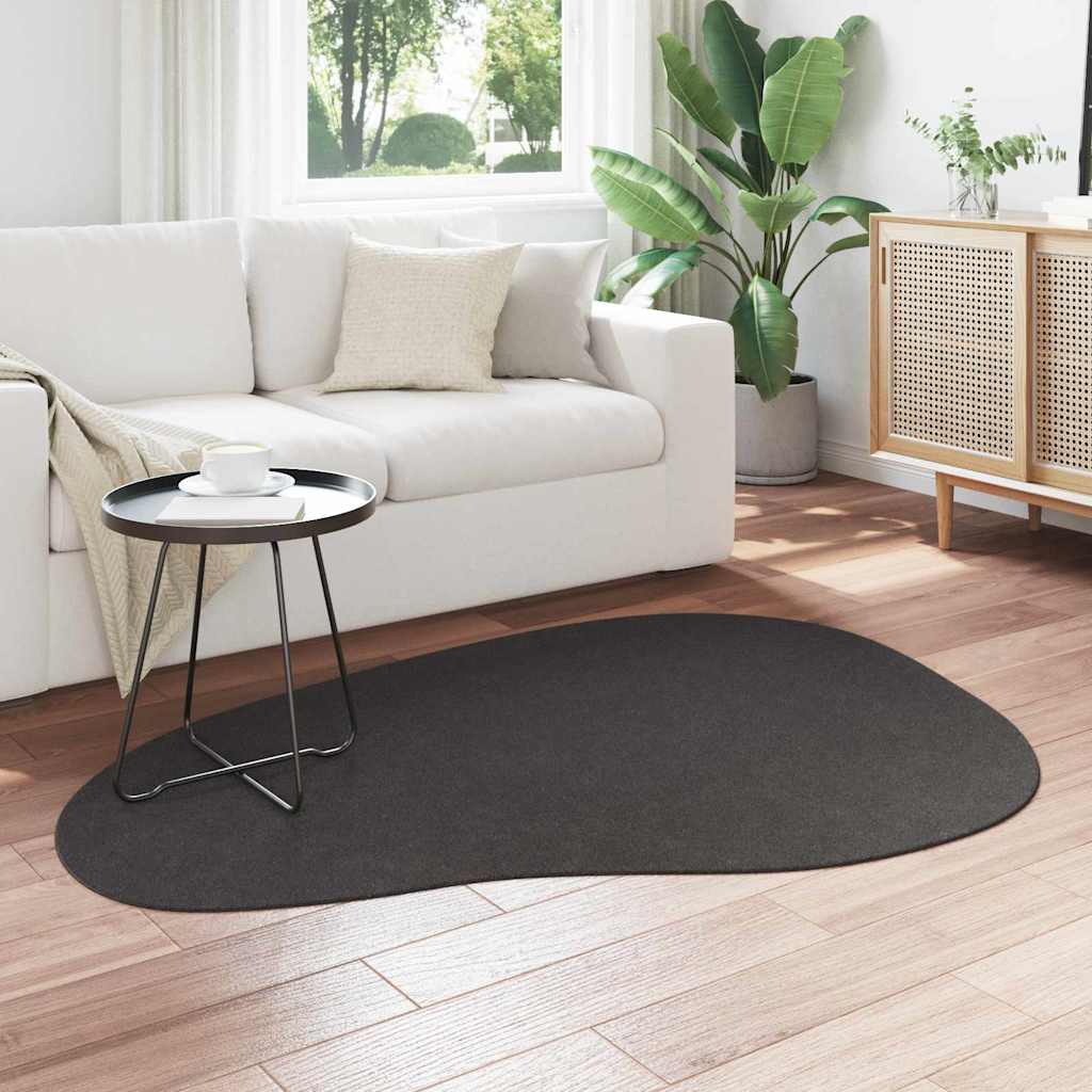 Carpet HUARTE Anthracite, the dark grey rug placed on a light wooden floor in front of a white sofa
