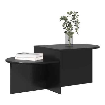 The black coffee table with a stack of books on its lower shelf