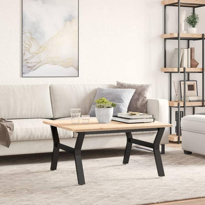 A wooden tabletop attached to the black steel Y-frame table legs in a living room setting