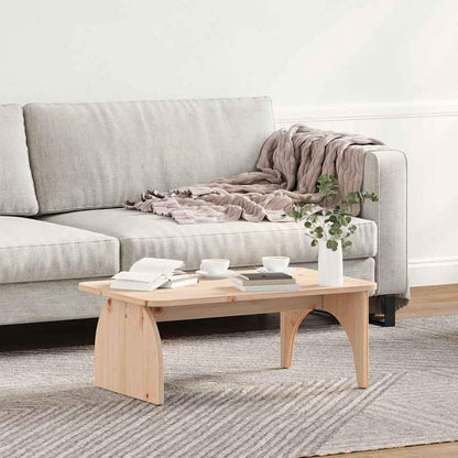 A natural pine wood coffee table placed in front of a sofa on a rug