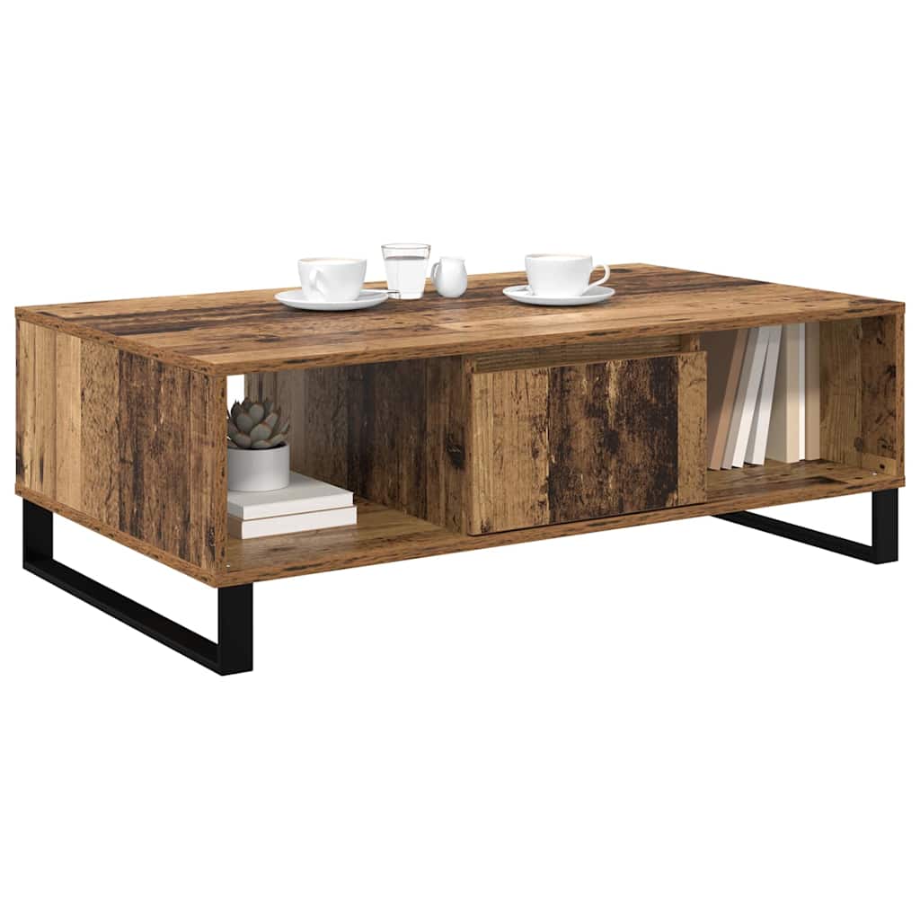 the coffee table styled with cups and a small plant on the surface and books in the shelf