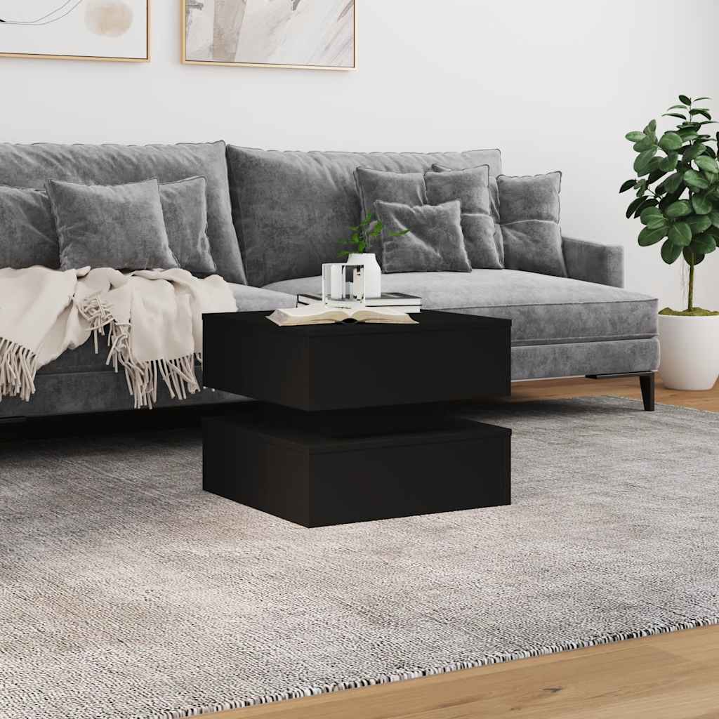 Black coffee table in a living room setting with a grey sofa and rug