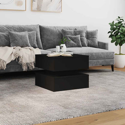 Black coffee table in a living room setting with a grey sofa and rug