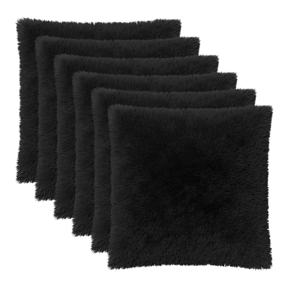 Six black cushion covers with a fluffy texture arranged in a row