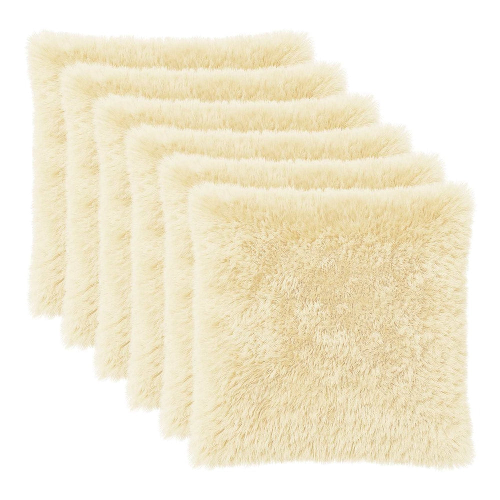 Six cream fluffy pillow covers arranged in a stack