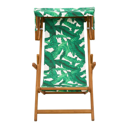 Front view of the wooden deck chair with a green leaf pattern fabric and canopy
