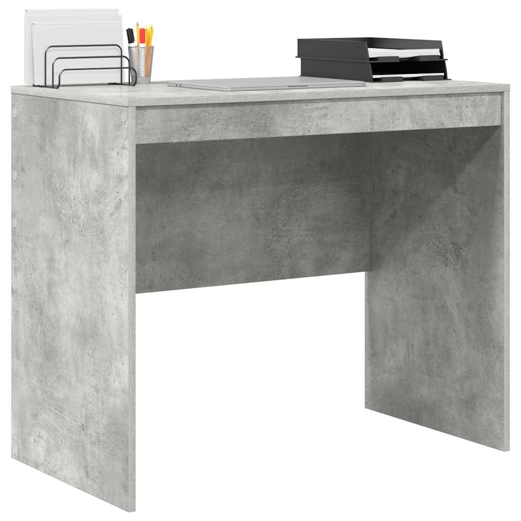 Concrete grey desk with a laptop and office supplies on top