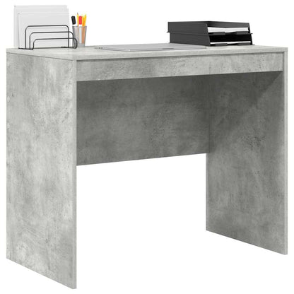 Concrete grey desk with a laptop and office supplies on top