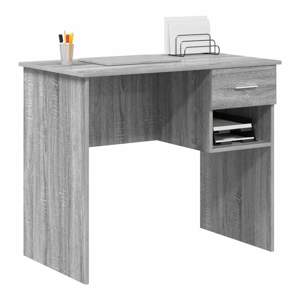 This grey engineered wood desk is set up with a laptop and office supplies, showing its usability