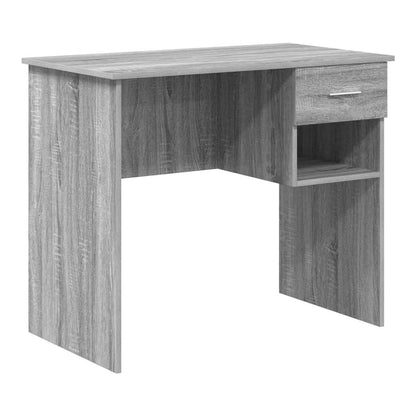 The grey engineered wood desk is shown from the front, highlighting its simple design and storage cubby