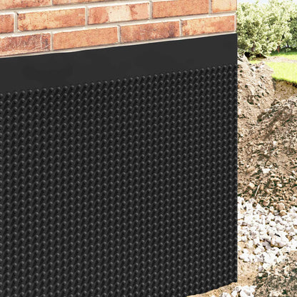 Black dimpled drainage sheet installed against a brick wall