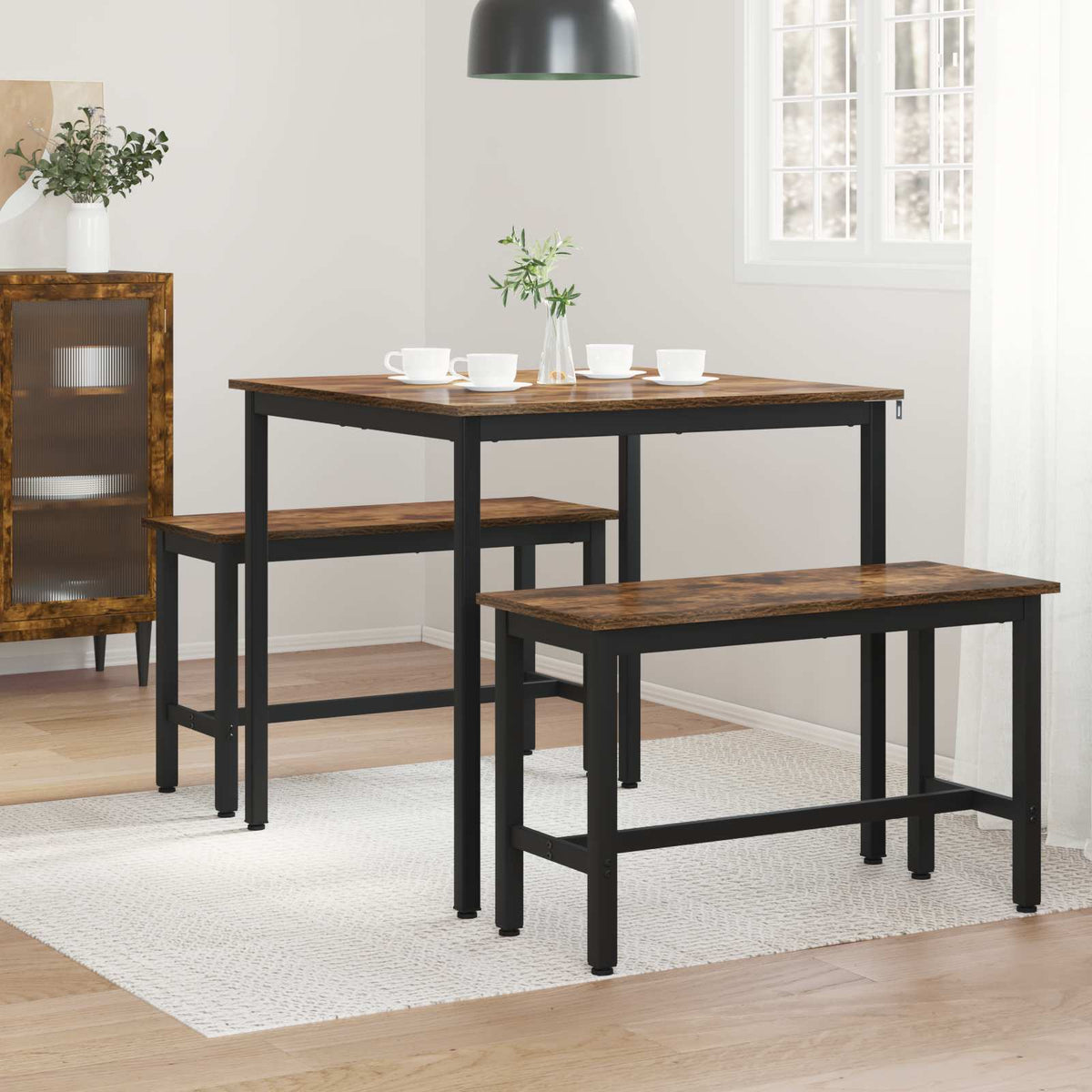 the dining table and two matching benches positioned on a light rug in a living space