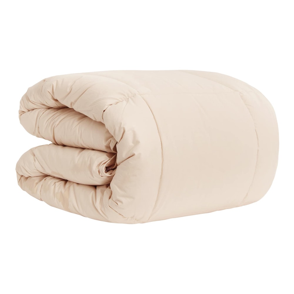 A beige winter duvet folded in half, showing its soft quilted texture