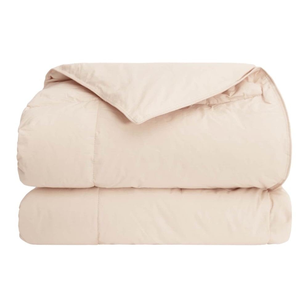 The beige winter duvet is folded, revealing its smooth fabric and quilted pattern