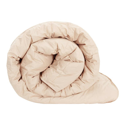 A beige winter duvet rolled up, showing its soft texture and quilted design