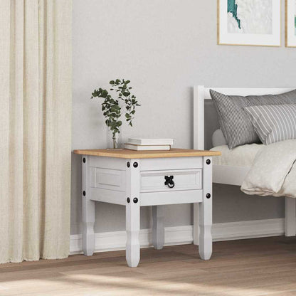 The white end table in a bedroom setting next to a bed