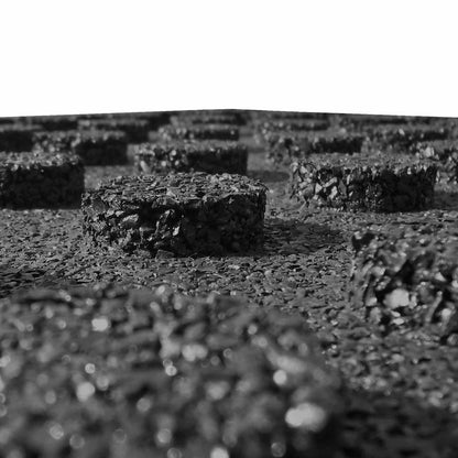 close up of the underside of black rubber fall protection tiles showing the raised circular studs
