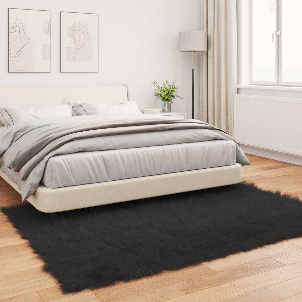 The black faux sheepskin rug placed on a wooden floor next to a bed