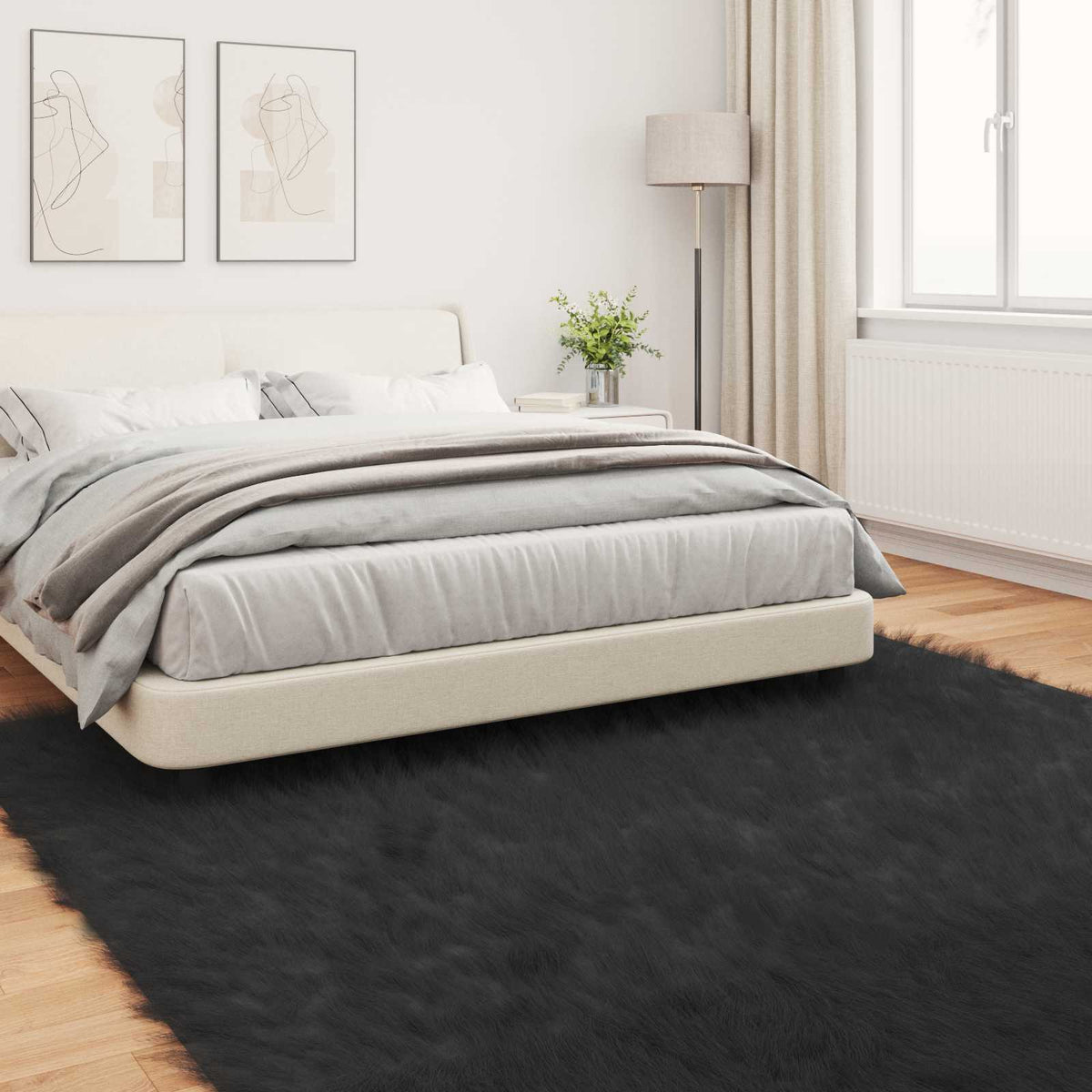 The black faux sheepskin rug placed on a wooden floor next to a bed
