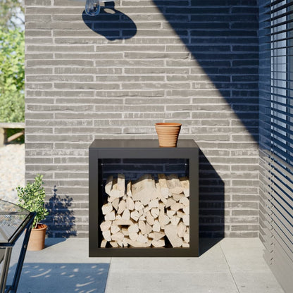 vidaXL Firewood Rack Black filled with logs on a patio against a grey brick wall