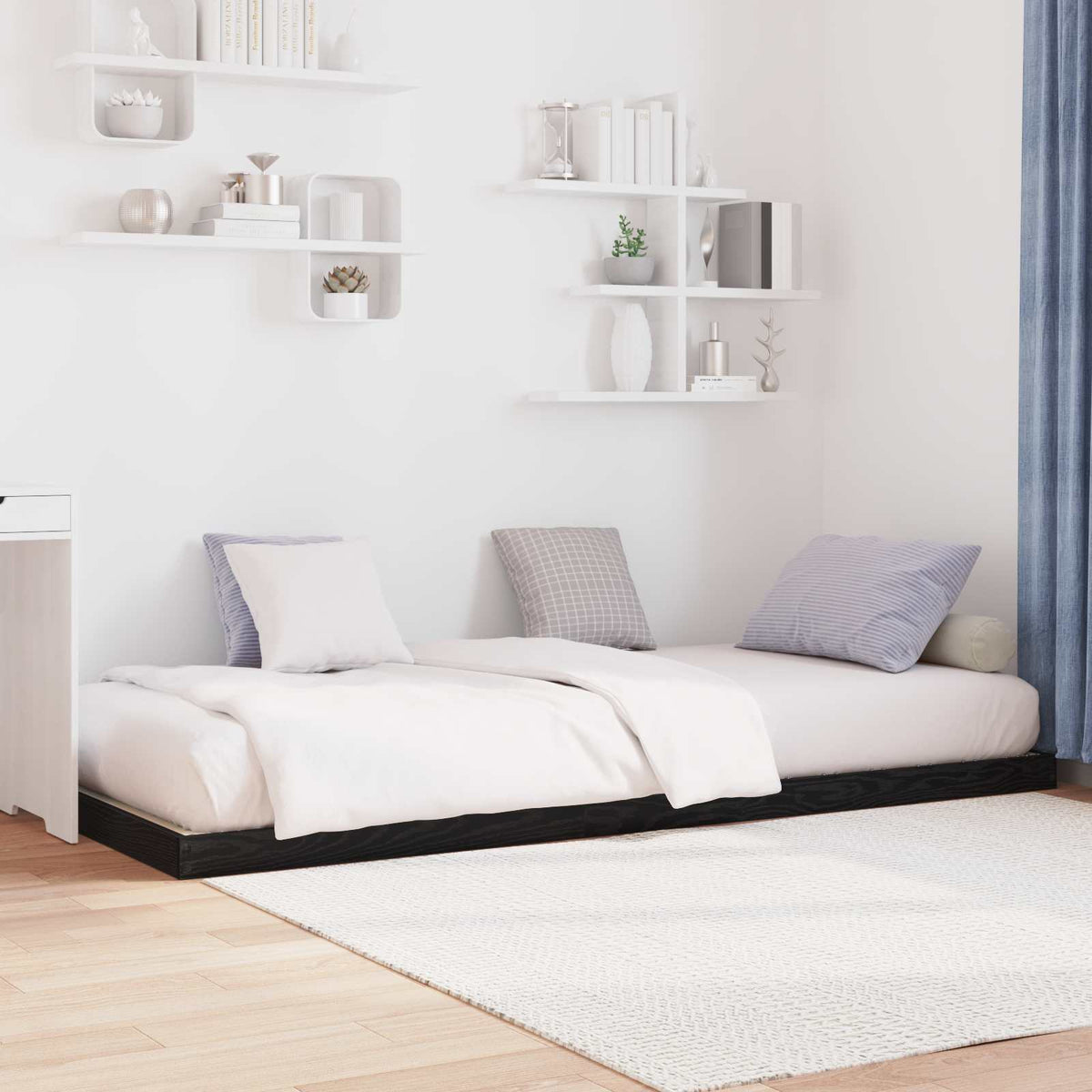 Two black oak floor bed frames pushed together in a room