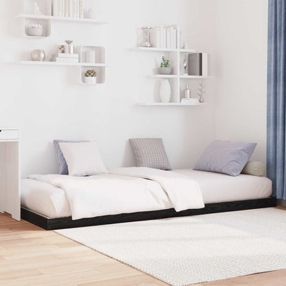 Two black oak floor bed frames pushed together in a room