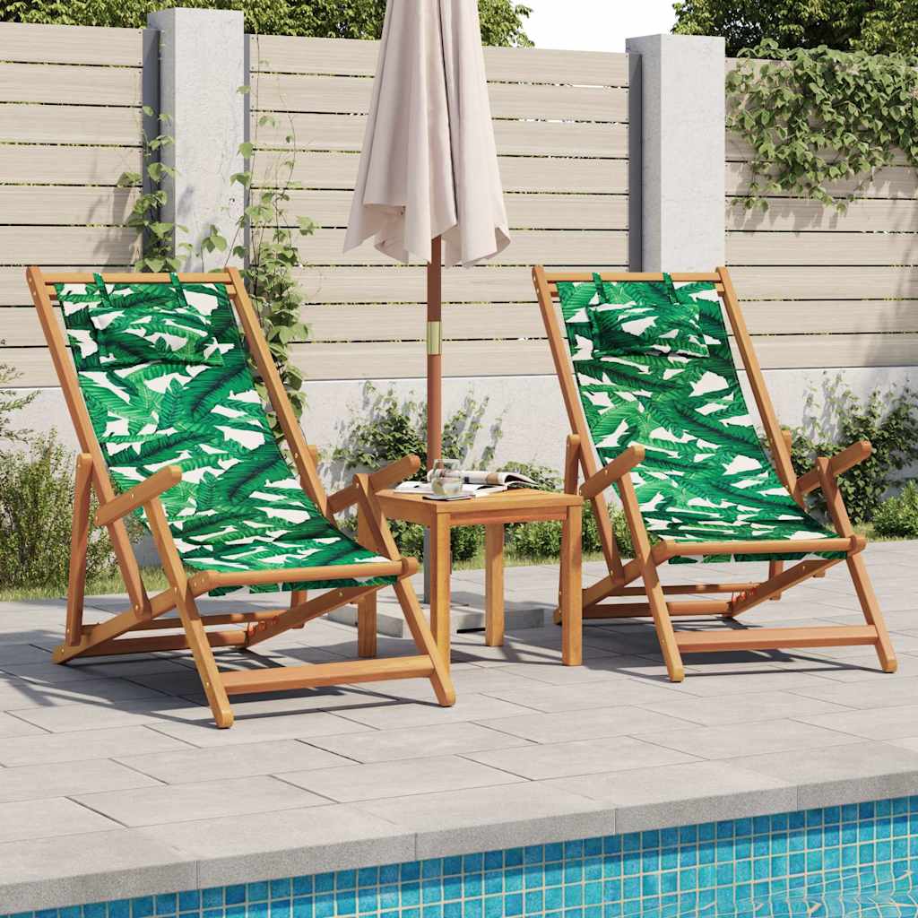 Two folding outdoor chairs with leaf pattern fabric sit beside a small wooden table and parasol