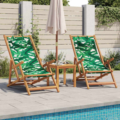 Two folding outdoor chairs with leaf pattern fabric sit beside a small wooden table and parasol