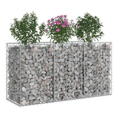 Three sections of a gabion raised garden bed filled with stones and plants