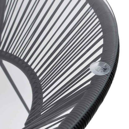 Close-up of the black rattan weave and glass tabletop of the outdoor table