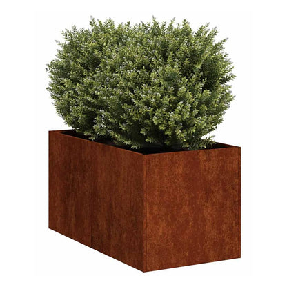 The rusty weathering steel planter with a green bush inside, shown outdoors