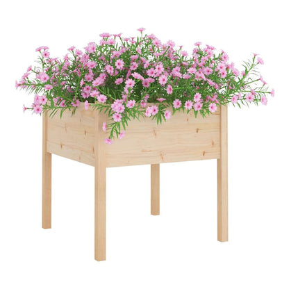 A light wood square garden planter on four legs, filled with pink flowers