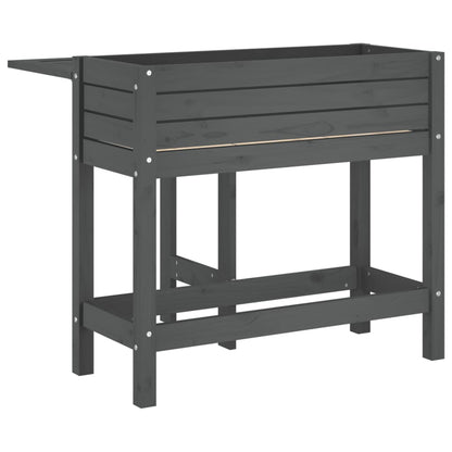 A grey wooden garden planter with a fold-out table, shown from the side with the table extended
