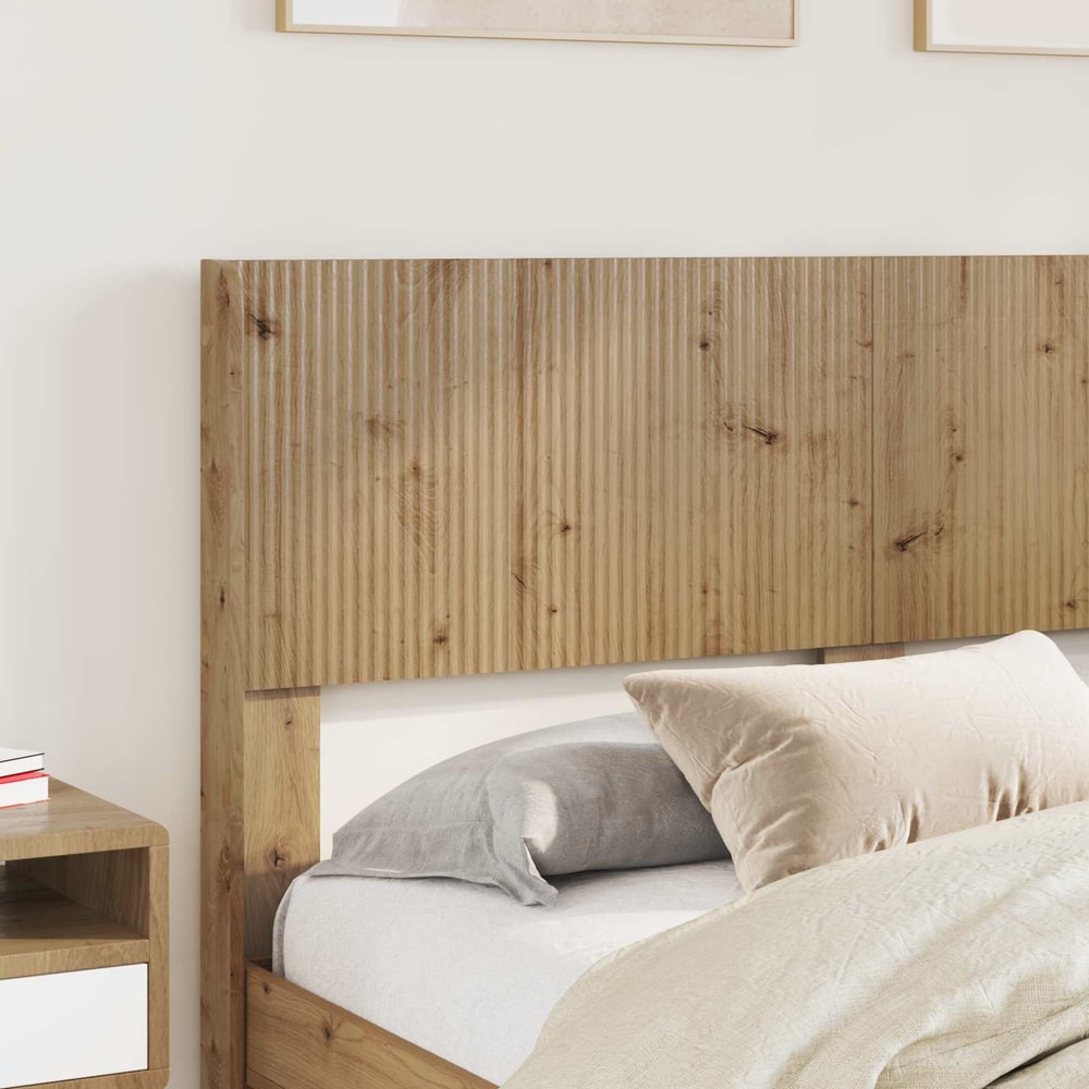The headboard is fitted to a bed with pillows and bedding