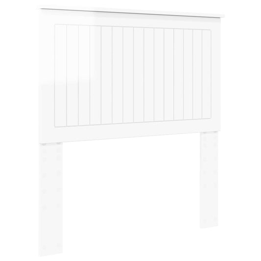 The white headboard featuring vertical panel detailing and two sturdy support legs