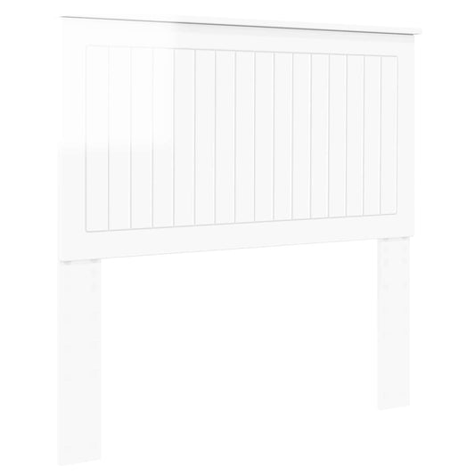 The white headboard has vertical panel detailing and stands on two legs