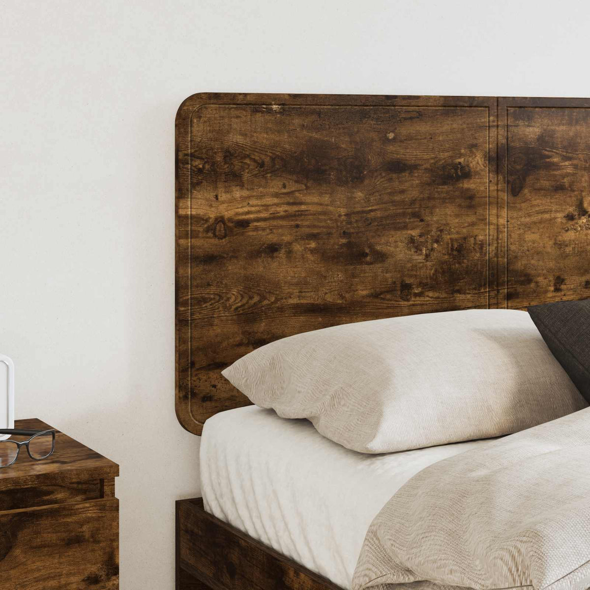 Close up of the headboard showing the dark wood texture behind a bed with pillows