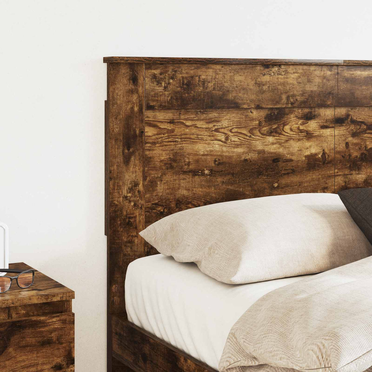 the headboard positioned behind a bed with pillows and a bedside table