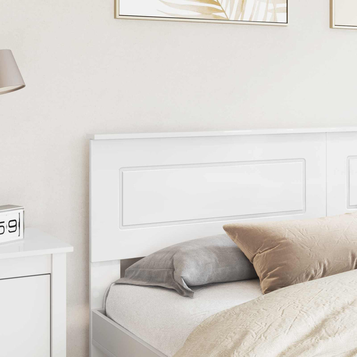 A close-up of the white headboard panel next to a bedside table with a lamp