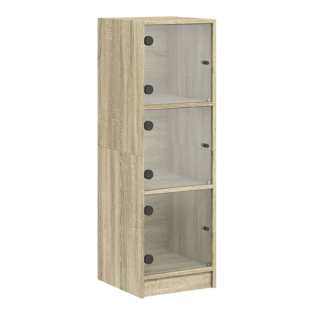 the tall narrow cabinet with three glass doors and shelves inside, shown against a white wall
