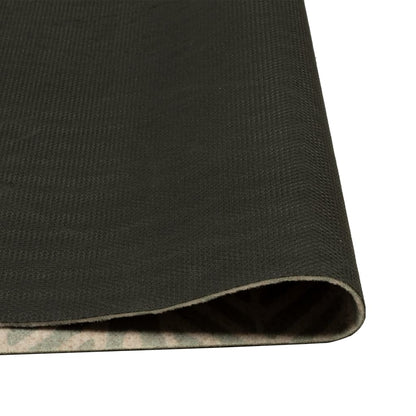 The kitchen rug corner folded to reveal the black textured underside
